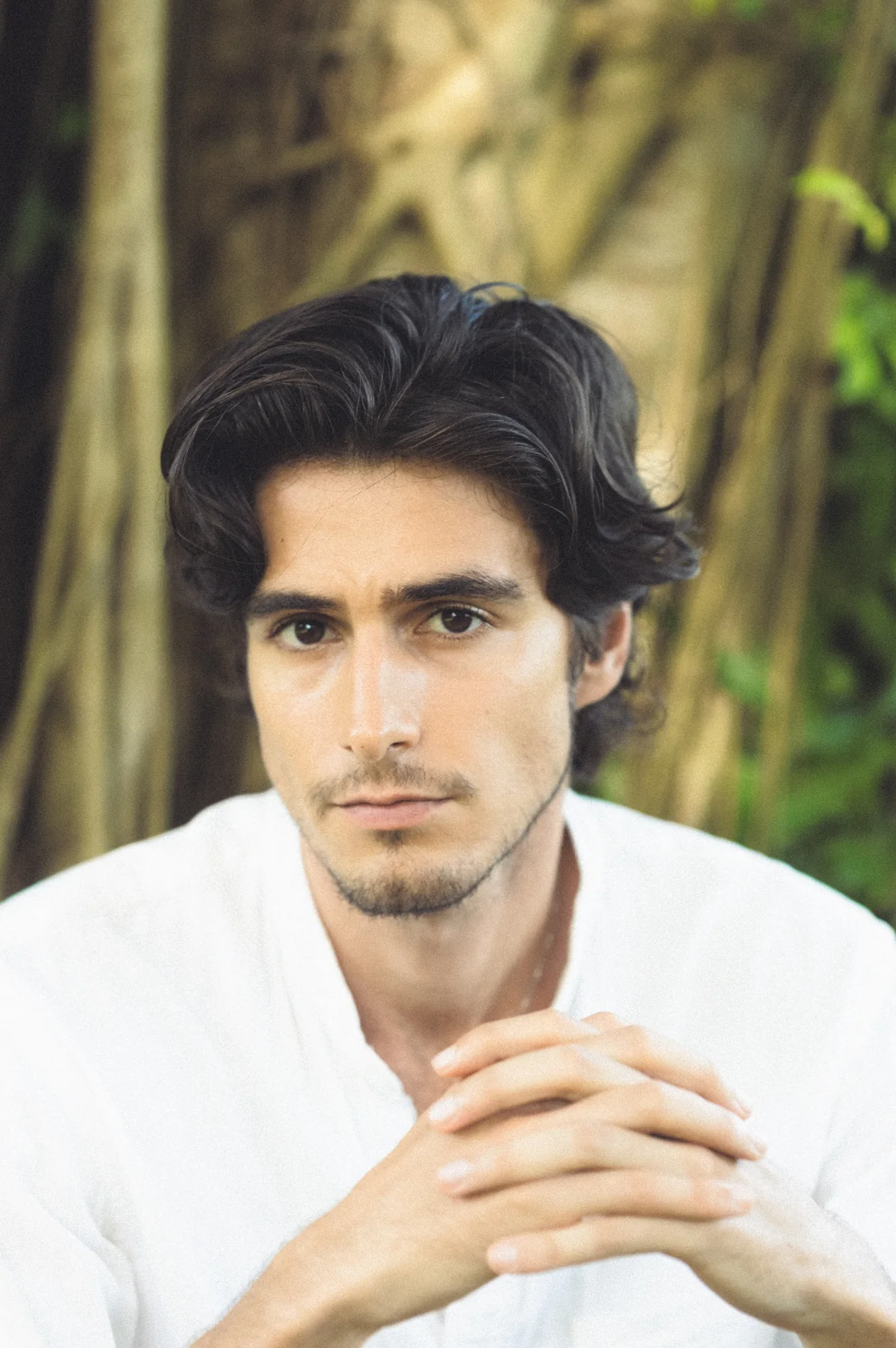 Headshot of Luca Bold in a white shirt against blurred trees